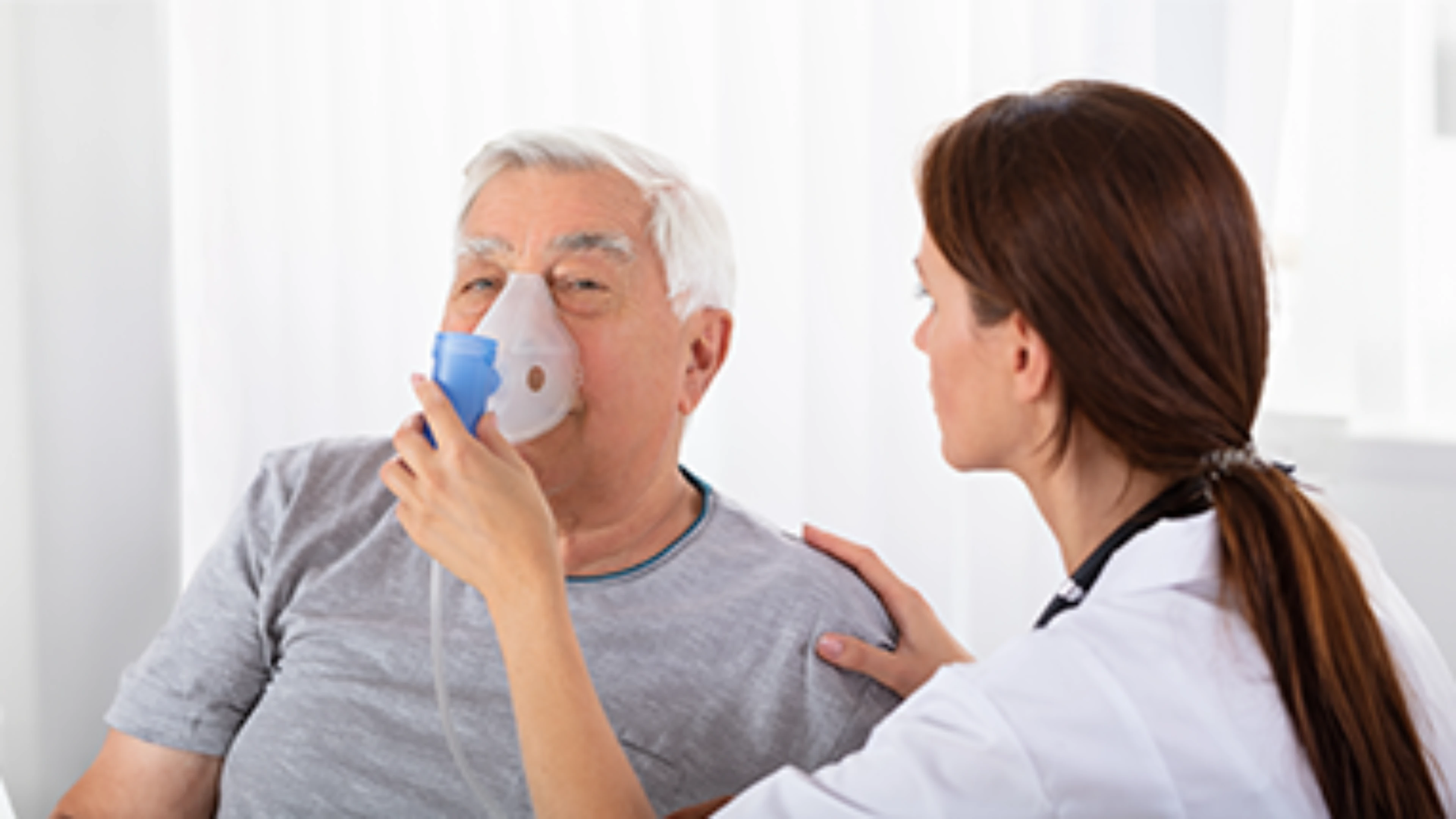 Nurse placing a respiratory mask on a patient