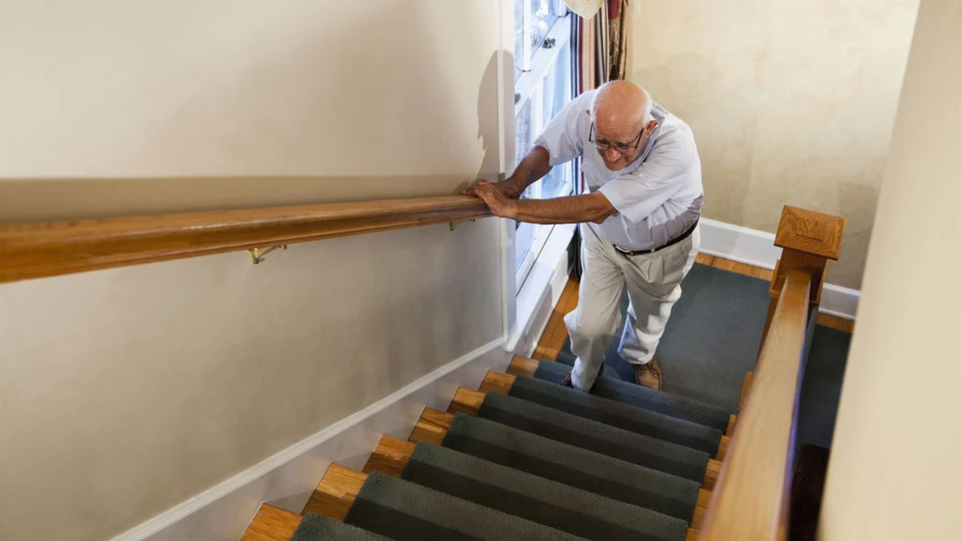 Homme rencontrant des difficultés à monter les escaliers en raison de sa maladie neuromusculaire qui impacte sa mobilité.