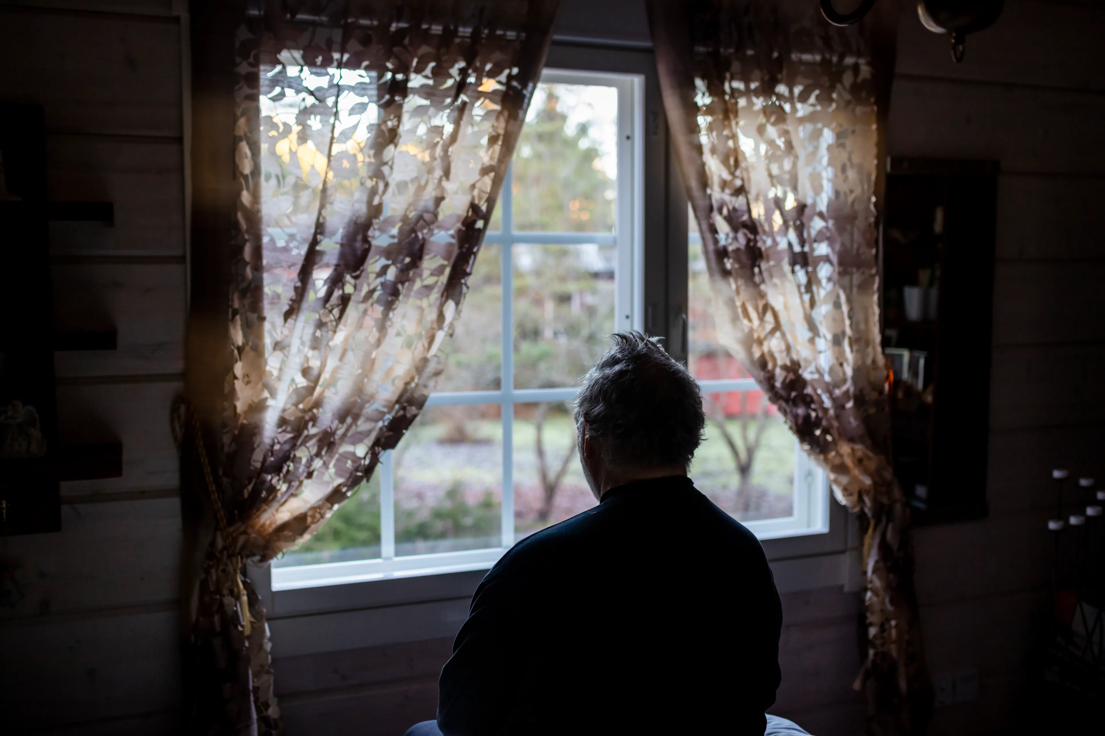 Homme âgé solitaire regardant par la fenêtre