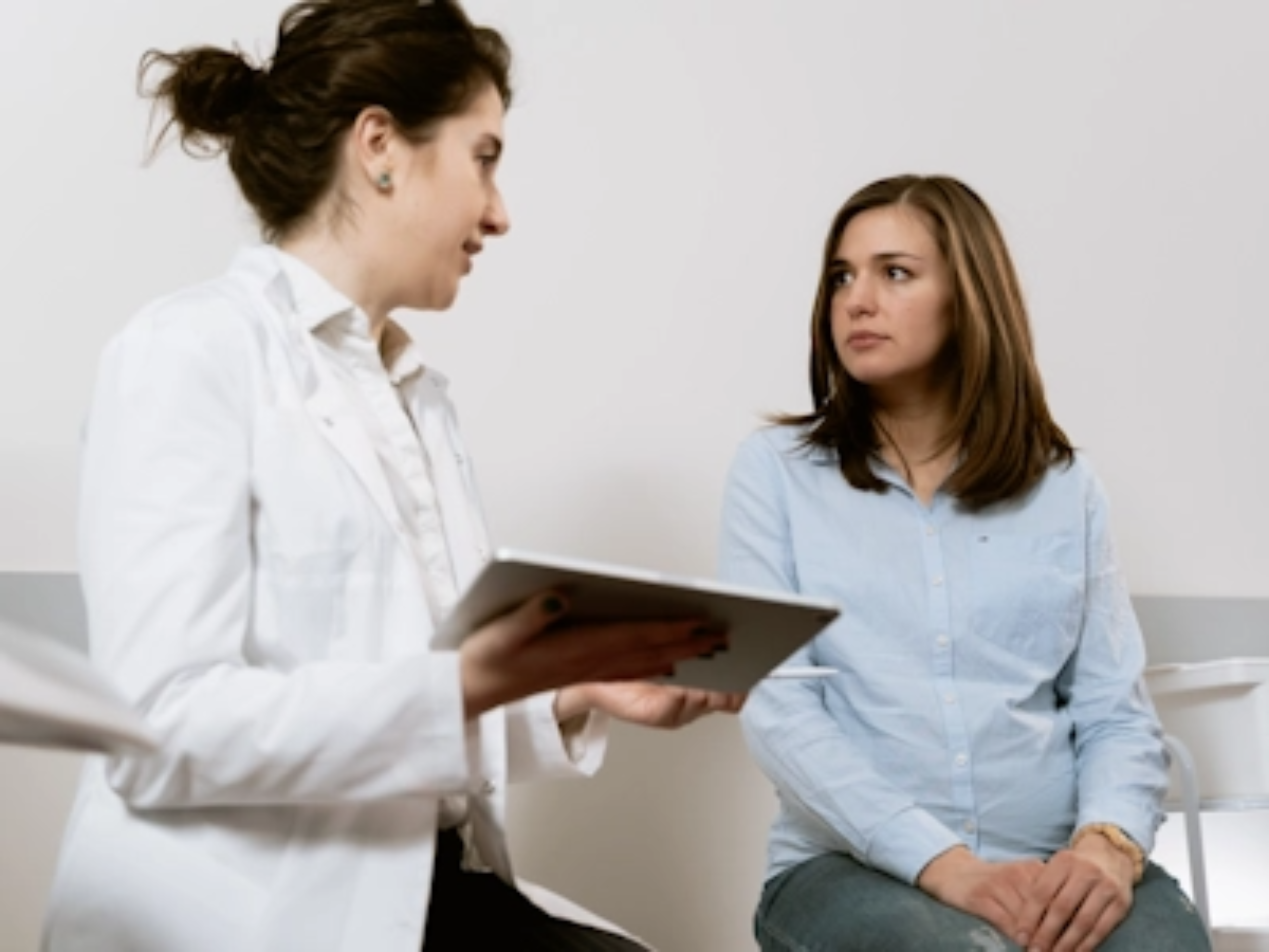 Ärztin im Gespräch mit erwachsener Patientin symbolisiert Diagnose ASMD im Erwachsenenalter