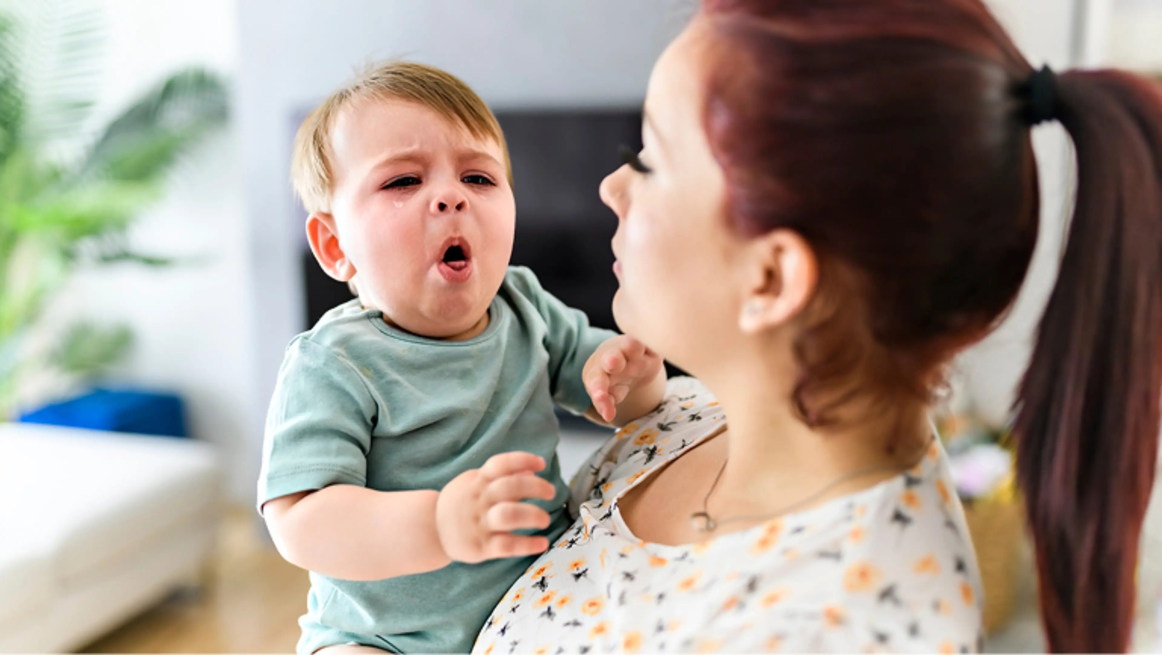 Frau hält hustendes Baby im Arm
