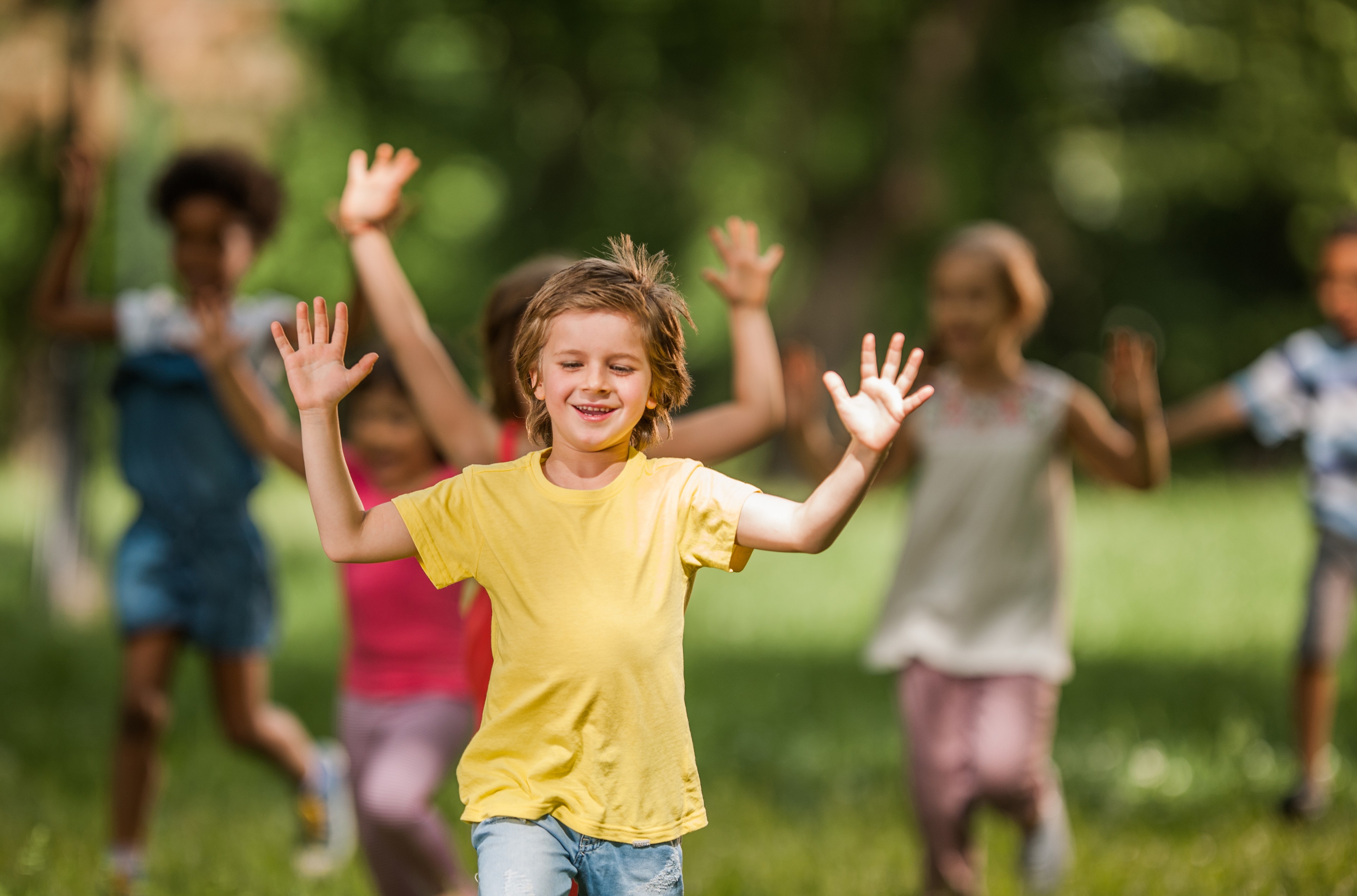 Boy is running in the parc with friends