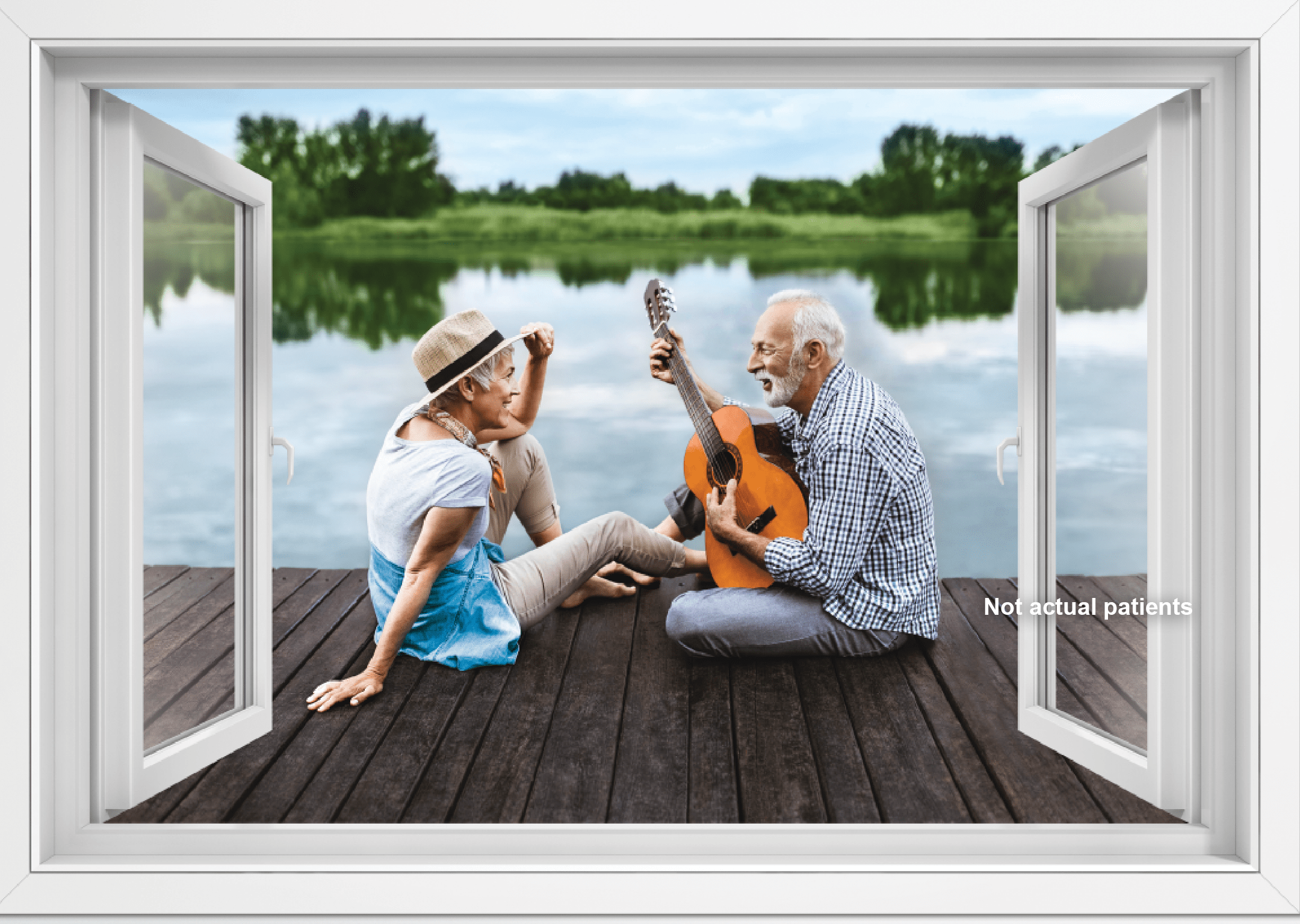 A couple sits on a wooden deck overlooking a lake. The man is playing guitar.