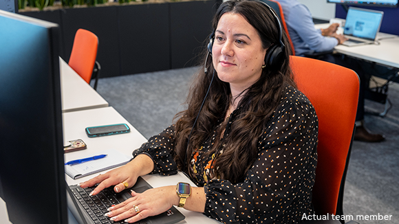 A HemAssist team member sitting in front of her computer at her desk