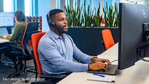 Portrayal of a smiling man sitting at a desk wearing a headset