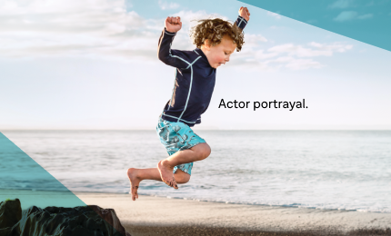 Boy at beach jumping off rocks
