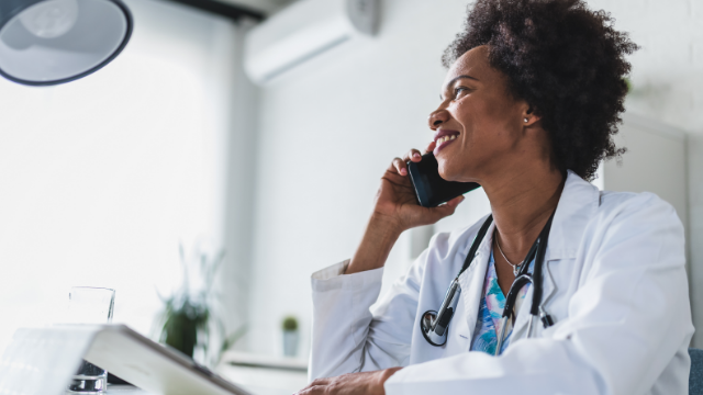 A healthcare professional smiling and speaking on a mobile phone