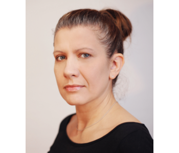 Eine Frau mit ernster Miene blickt in die Kamera, symbolisiert Patientenkasuistik in der Kardiologie.